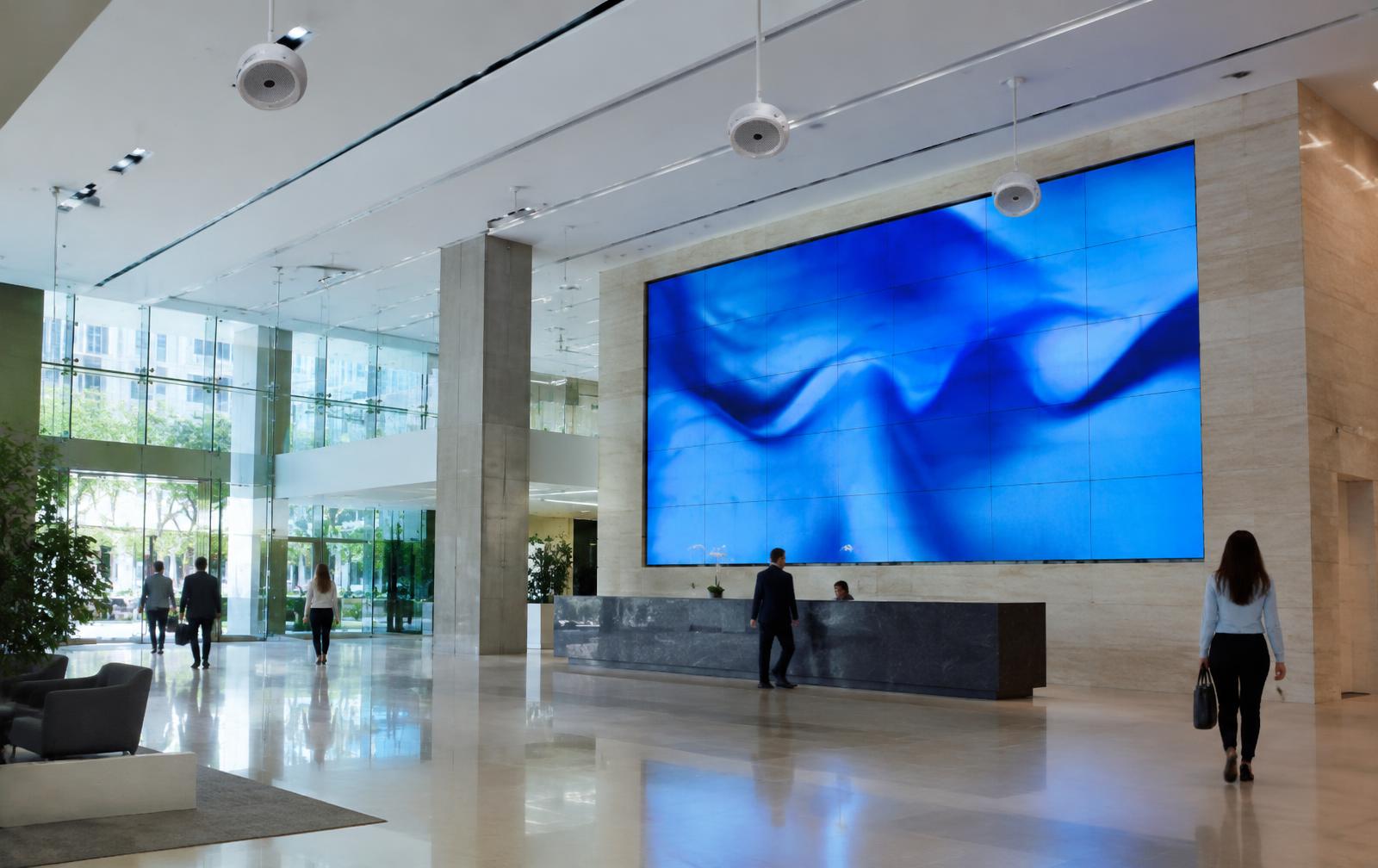 Commercial office lobby with a large LED video wall and ceiling speakers